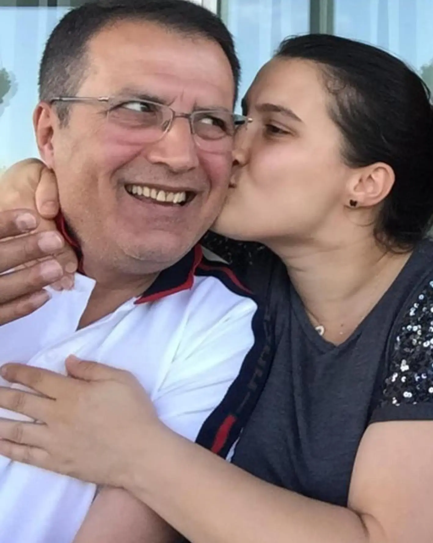Samad receiving a kiss from his daughter